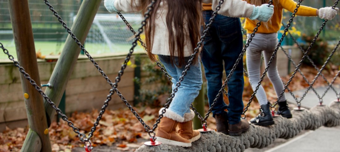Das Bild zeigt Kinder, die auf einem Seil balancieren.